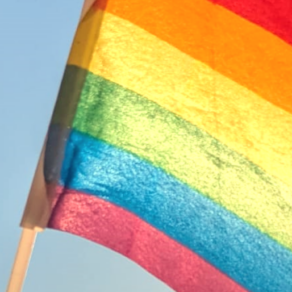 eine postkarte mit der aufschrift "bunte grüße aus der gruga-region" neben einer regenbogenflagge
